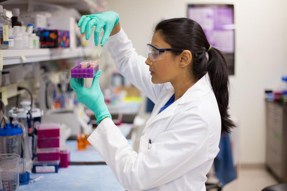 Woman holding up a rack of vials