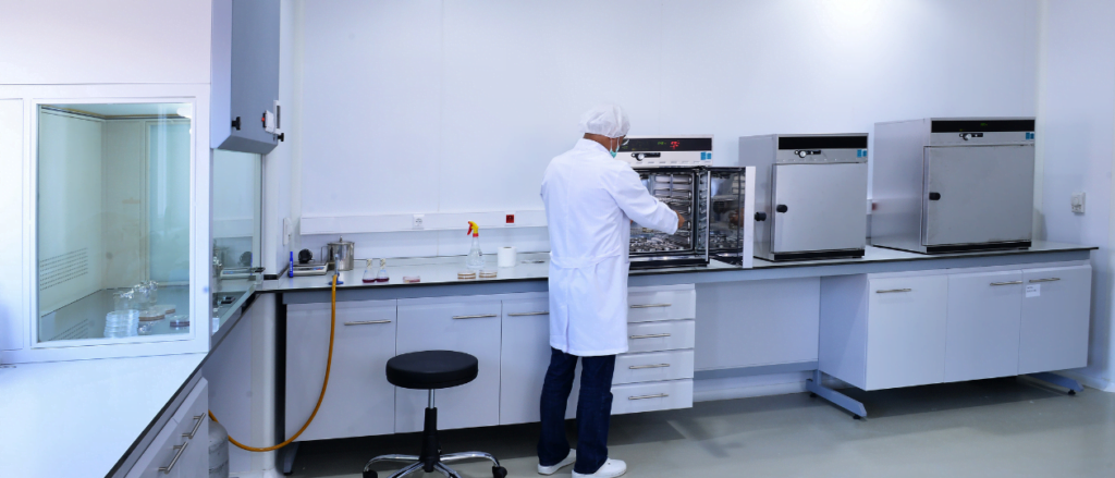 Scientist placing laboratory equipment into an autoclave in the lab